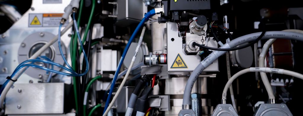 The hand of a scientist is shown using the equipment