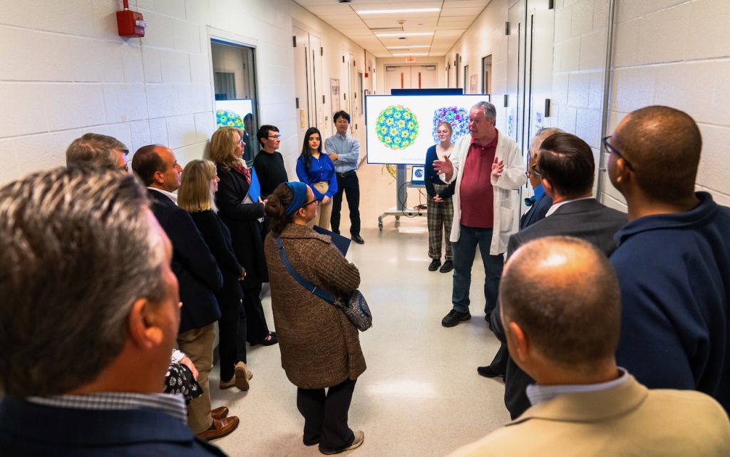 Nigel Deighton speaking to members of the Penn State Board of Trustees in a hallway