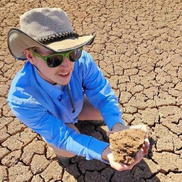 Matt Langland, who recently graduated from Penn State with a bachelor’s degree in environmental resource management, examines salt-encrusted soils in New Mexico's migratory bird habitats. Credit: Contributed photo. All Rights Reserved.