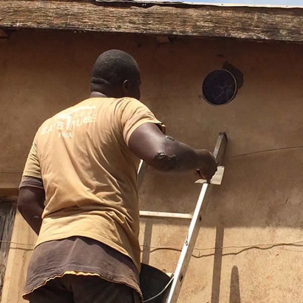 A man inspects an "Eave Tube" used to intercept and kill mosquitoes CREDIT: Matthew Thomas