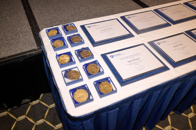 Awards and medals on a table at the 2023-24 Graduate Student Awards, hosted by the Graduate School at Penn State.