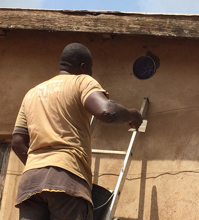 A man inspects an "Eave Tube" used to intercept and kill mosquitoes CREDIT: Matthew Thomas